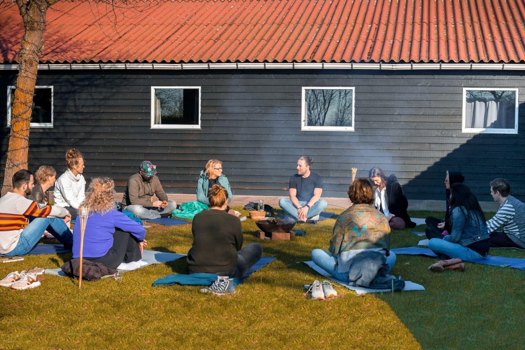 Deelnemers tijdens een yoga retreat in een serene natuurlijke omgeving, meditatieve pose