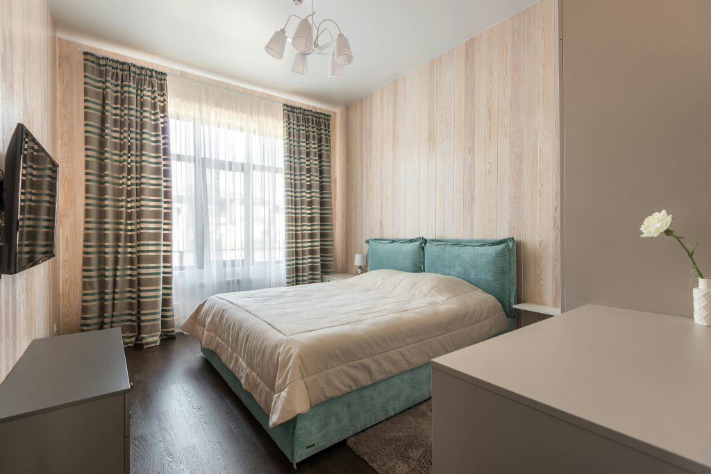 Goed ingerichte kleine slaapkamer met efficiënte indeling, multifunctionele meubels en neutrale kleuren voor een ruim en geze